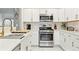 Modern kitchen featuring stainless steel appliances, white cabinets and countertops, and gold hardware at 5926 S Jellison St # B, Littleton, CO 80123