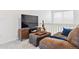 Comfortable living room with brown sectional, TV, guitar, and neutral walls at 5926 S Jellison St # B, Littleton, CO 80123