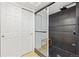 Contemporary shower features black honeycomb tiles, a glass enclosure, and a convenient bench at 5926 S Jellison St # B, Littleton, CO 80123