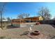 Backyard with deck, gravel, fire pit, chairs, and partially fenced yard at 7970 Wolff Ct, Westminster, CO 80030