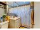 Cozy bathroom featuring a vanity with storage, patterned shower curtain, and tiled floor at 7970 Wolff Ct, Westminster, CO 80030