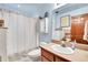 Bright bathroom with a vanity sink, a shower with white shower curtain and lots of cabinet storage at 29857 Park Village Dr, Evergreen, CO 80439