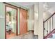 Hallway featuring wood sliding door, tile floor, and staircase at 29857 Park Village Dr, Evergreen, CO 80439