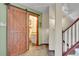 Hallway featuring wood sliding door, tile floor, and staircase at 29857 Park Village Dr, Evergreen, CO 80439