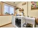 Well-lit laundry room with modern washer and dryer, sink, and charming decor at 29857 Park Village Dr, Evergreen, CO 80439