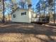 Back exterior of home showing a cozy deck and lots of privacy surrounded by a lovely treed property at 36351 County Road 21, Elizabeth, CO 80107