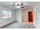 This bedroom has neutral gray carpeting, a ceiling fan, and a wooden door to the closet area at 53 S Eagle Cir, Aurora, CO 80012