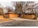 Cozy home with a two-car garage, wooden siding, mature trees and a concrete driveway at 53 S Eagle Cir, Aurora, CO 80012