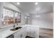 Bright kitchen with white cabinets, quartz countertops, and stainless steel sink overlooking the backyard at 53 S Eagle Cir, Aurora, CO 80012