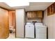 This laundry room has a washer, dryer, and adjacent toilet area at 53 S Eagle Cir, Aurora, CO 80012