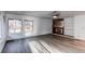 Spacious living room featuring a fireplace, built-in shelving, large windows, and modern gray woodgrain flooring at 53 S Eagle Cir, Aurora, CO 80012
