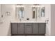 Updated bathroom features double sinks, stone countertop, modern mirrors and ample lighting at 112 W Sterne Pkwy, Littleton, CO 80120