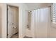 Bathroom featuring a shower-tub combo with tile surround and an adjacent doorway to the toilet at 112 W Sterne Pkwy, Littleton, CO 80120