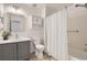 Bathroom featuring a single vanity with a tub-shower combo, a decorative cabinet, and neutral tones at 112 W Sterne Pkwy, Littleton, CO 80120