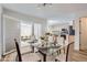 Stylish dining area open to kitchen with glass table, seating for six, and natural light flowing from adjacent patio at 112 W Sterne Pkwy, Littleton, CO 80120