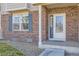 Close-up of the home's front door, showing the brick exterior and blue shutters at 112 W Sterne Pkwy, Littleton, CO 80120