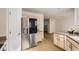 Open concept kitchen with stainless steel refrigerator, granite countertops, and views into the living area at 112 W Sterne Pkwy, Littleton, CO 80120