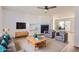 Open living room featuring a fireplace, a ceiling fan, and ample seating, with a dining area in the background at 112 W Sterne Pkwy, Littleton, CO 80120