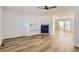 Bright living room featuring a cozy fireplace, wood flooring, and an open layout connecting to the dining area at 112 W Sterne Pkwy, Littleton, CO 80120