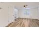 Bright living room with wood flooring, white walls, ceiling fan, and open layout to front door and large, shuttered window at 112 W Sterne Pkwy, Littleton, CO 80120