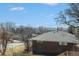 Backyard view showing the red brick home with mature trees and neighborhood scenery at 7077 Ammons St, Arvada, CO 80004