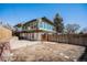 Home's backyard with a modern exterior featuring large glass windows at 7077 Ammons St, Arvada, CO 80004