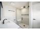 Modern bathroom featuring a glass enclosed shower with stone accents, and a quartz vanity at 7077 Ammons St, Arvada, CO 80004