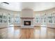 Bright living room featuring a modern fireplace with stone facade and ample windows at 7077 Ammons St, Arvada, CO 80004