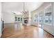 Bright living room showcasing fireplace, large windows, hardwood floors, and access to sunroom at 7077 Ammons St, Arvada, CO 80004