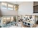 Bright living room featuring a vaulted ceiling, island with seating, and access to an outdoor patio at 8836 Whiteclover St, Littleton, CO 80125