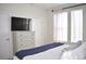 Cozy bedroom with a dresser, a large TV and lots of natural light from the windows at 2147 N Downing St, Denver, CO 80205