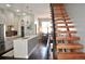 Modern kitchen with an island, stainless steel appliances, and adjacent dining area with wood stairs at 2147 N Downing St, Denver, CO 80205