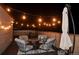 Atmospheric rooftop deck with ambient string lights, plush seating, and an umbrella for nighttime gatherings at 2147 N Downing St, Denver, CO 80205