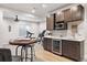 Basement bar area features a sink, a fridge, and cabinets for easy entertaining and enjoying at 7950 Piney River Ave, Littleton, CO 80125