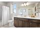 Well-lit bathroom showcasing a dark vanity, white countertop, and tiled shower with modern fixtures at 7950 Piney River Ave, Littleton, CO 80125