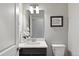 Modern bathroom with vanity, mirror, decorative artwork, toilet, and shower with white marble-style tile at 7950 Piney River Ave, Littleton, CO 80125
