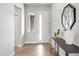 Bright entryway with hardwood floors, white door, a console table with decorative items and a modern mirror at 7950 Piney River Ave, Littleton, CO 80125
