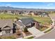 Aerial view of a home with a two-car garage, a fenced yard, and mountain views at 7950 Piney River Ave, Littleton, CO 80125