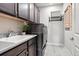 Modern laundry room equipped with sleek washer and dryer, custom cabinets, sink, and folding rack at 7950 Piney River Ave, Littleton, CO 80125