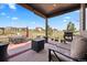 Covered patio includes a grill, comfortable seating, and a fire pit, offering views of the yard and neighborhood at 7950 Piney River Ave, Littleton, CO 80125