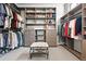 Spacious walk-in closet features custom shelving, drawers, and a seating area for convenient organization at 7950 Piney River Ave, Littleton, CO 80125