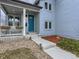 Home exterior featuring a blue front door, covered front porch with seating, and tasteful landscaping at 4628 Mt Shavano St, Brighton, CO 80601