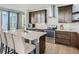 Modern kitchen featuring stainless steel appliances, a central island with seating, and dark wood cabinets at 4628 Mt Shavano St, Brighton, CO 80601
