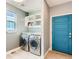 Laundry room with modern washer and dryer, utility sink, shelving and a blue door at 4628 Mt Shavano St, Brighton, CO 80601