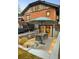 Outdoor dining on the patio beneath a colorful umbrella with views of the lush backyard at 1453 S Lafayette St, Denver, CO 80210