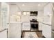 Modern white kitchen with stainless steel appliances, marble countertops, and sleek cabinetry at 1453 S Lafayette St, Denver, CO 80210