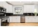 Well-lit kitchen with granite countertops, white cabinets, and stainless steel appliances at 1453 S Lafayette St, Denver, CO 80210