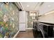 Stylish laundry room with monkey print wallpaper, modern washer/dryer, and custom shelving at 1453 S Lafayette St, Denver, CO 80210