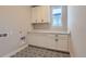 Functional laundry room with decorative tile flooring and ample cabinet space at 2962 Newfound Lake Rd, Berthoud, CO 80513