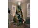 Festive Christmas tree adorned with gold and teal ornaments, topped with a star at 6470 Amur Ct, Castle Rock, CO 80108